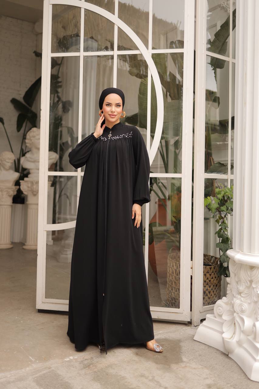 Front zipper black abaya featuring delicate pearls on the upper front, shown in a side pose.