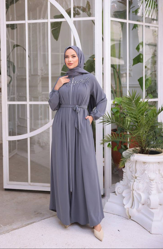 Chic grey abaya featuring  pearl details on the upper chest area, a front zipper closure, and matching waist belt for a flattering fit.