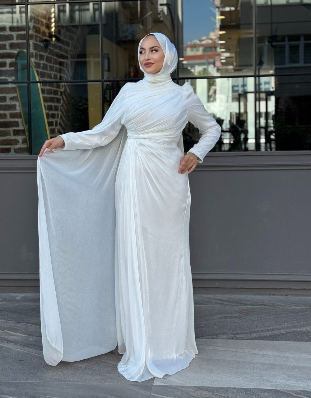 Graceful white formal gown featuring diagonal pleats, floor-length flow, and a matching hijab — ideal for engagement or reception events