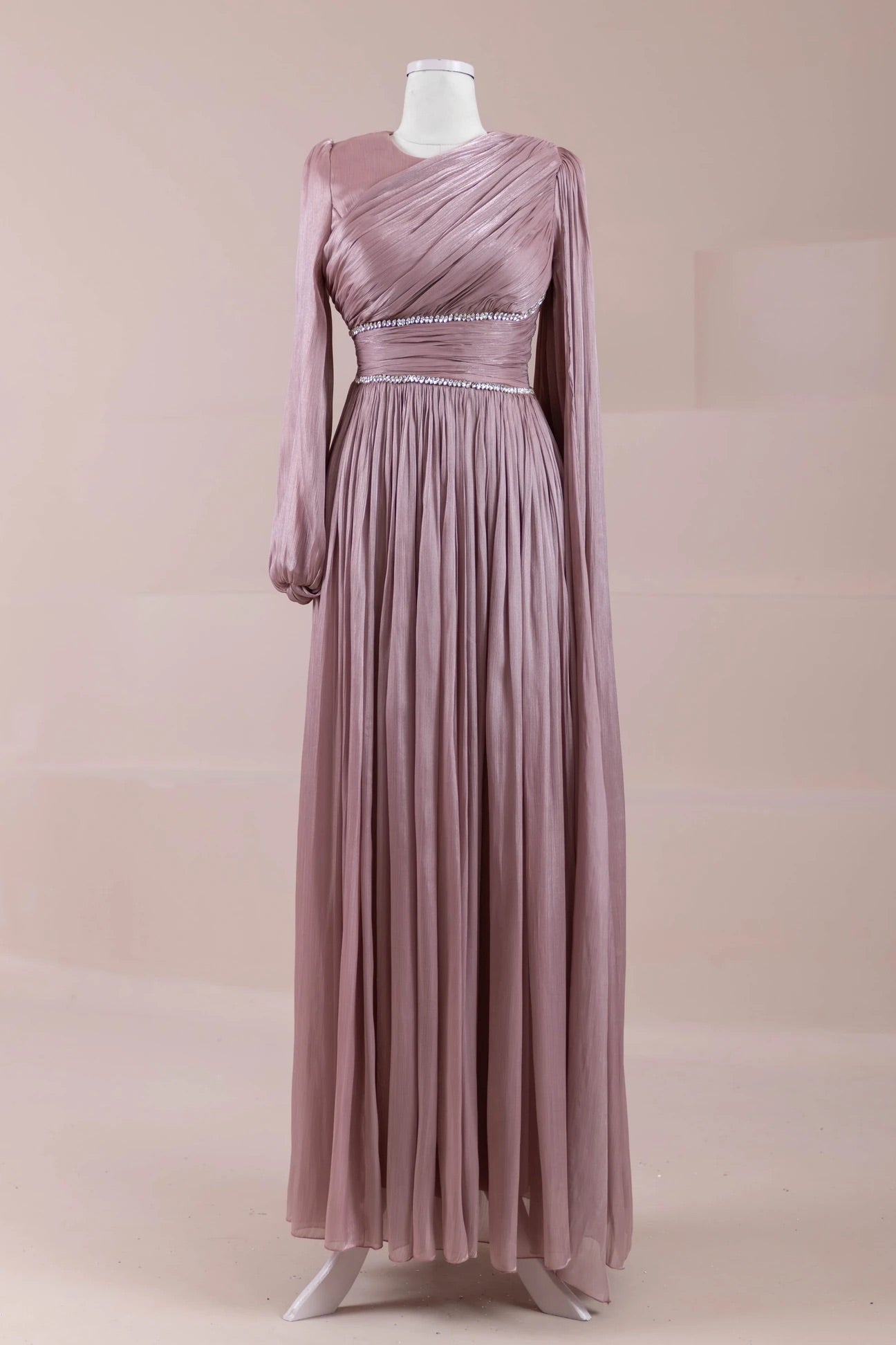 Front view of dusty rose pleated maxi dress with long sleeves and crystal waistband accents