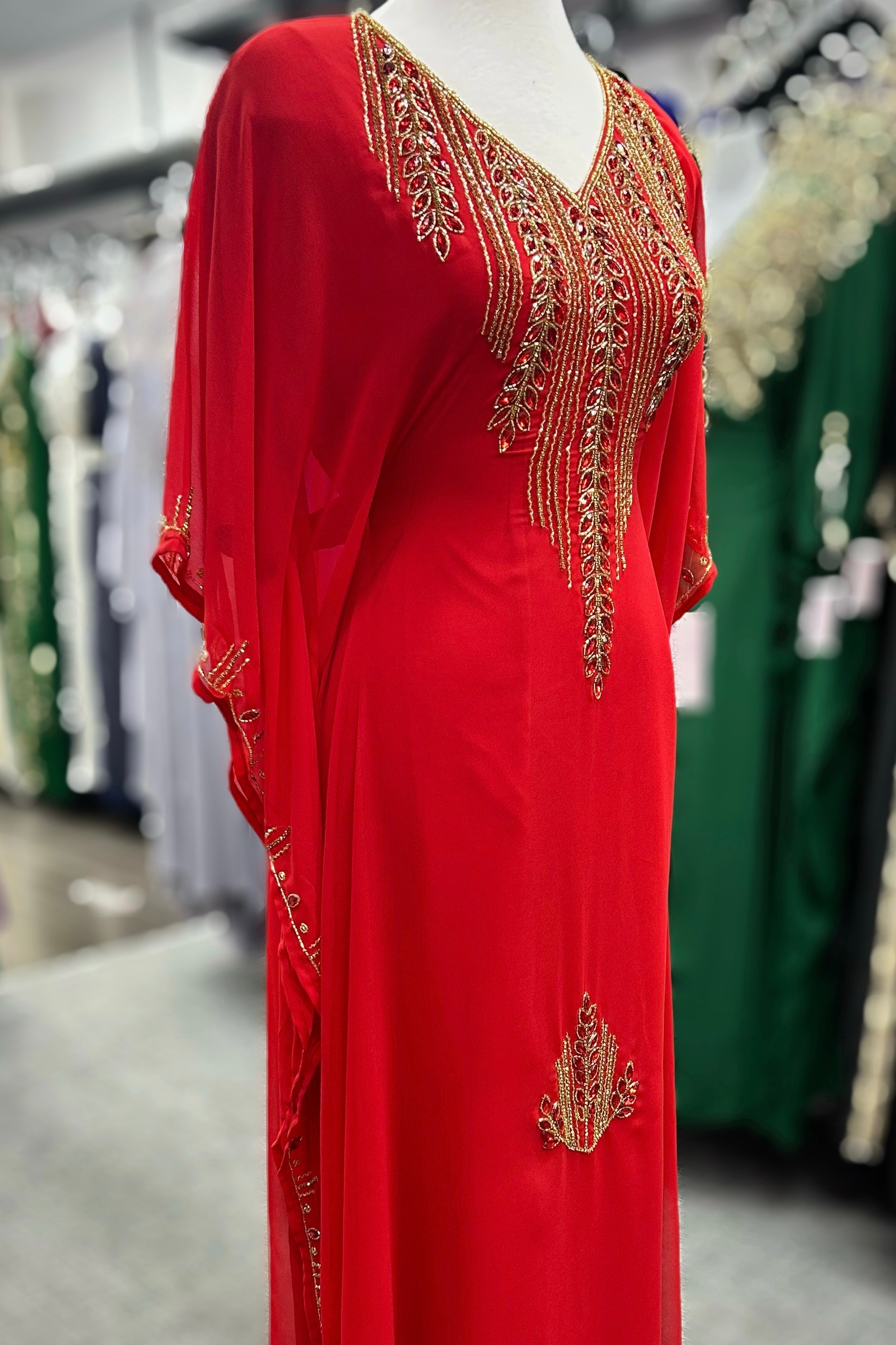 Elegant Red Dubai Farasha Caftan adorned with intricate gold and red rhinestone embroidery, exuding timeless sophistication. Designed with a comfortable, flowing silhouette and featuring an inner adjustable belt for a tailored fit. Perfect for special occasions and celebrations, this caftan combines luxurious detailing with effortless style.