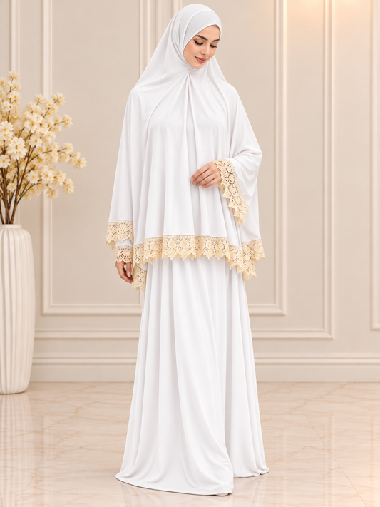 Elegant white 2-piece Islamic prayer set featuring a flowing khimar, matching full-length skirt, and delicate cream floral lace trim, modeled by a Muslim woman.