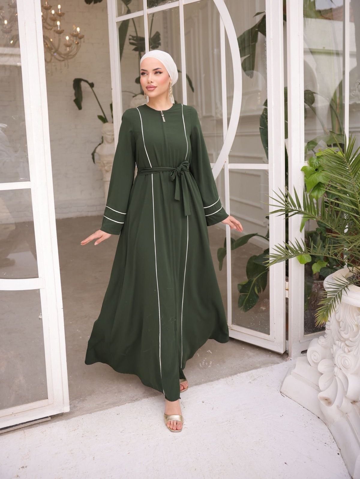 Chic green abaya featuring white contrast piping, a front zipper closure, and matching waist belt for a flattering fit.
